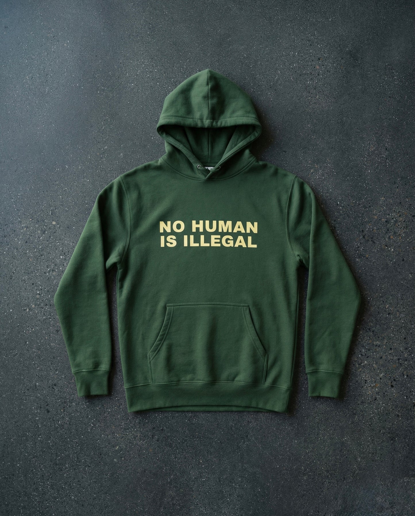 NO HUMAN IS ILLEGAL Hoodie Concrete Background in Forest | BAD BUREAU 