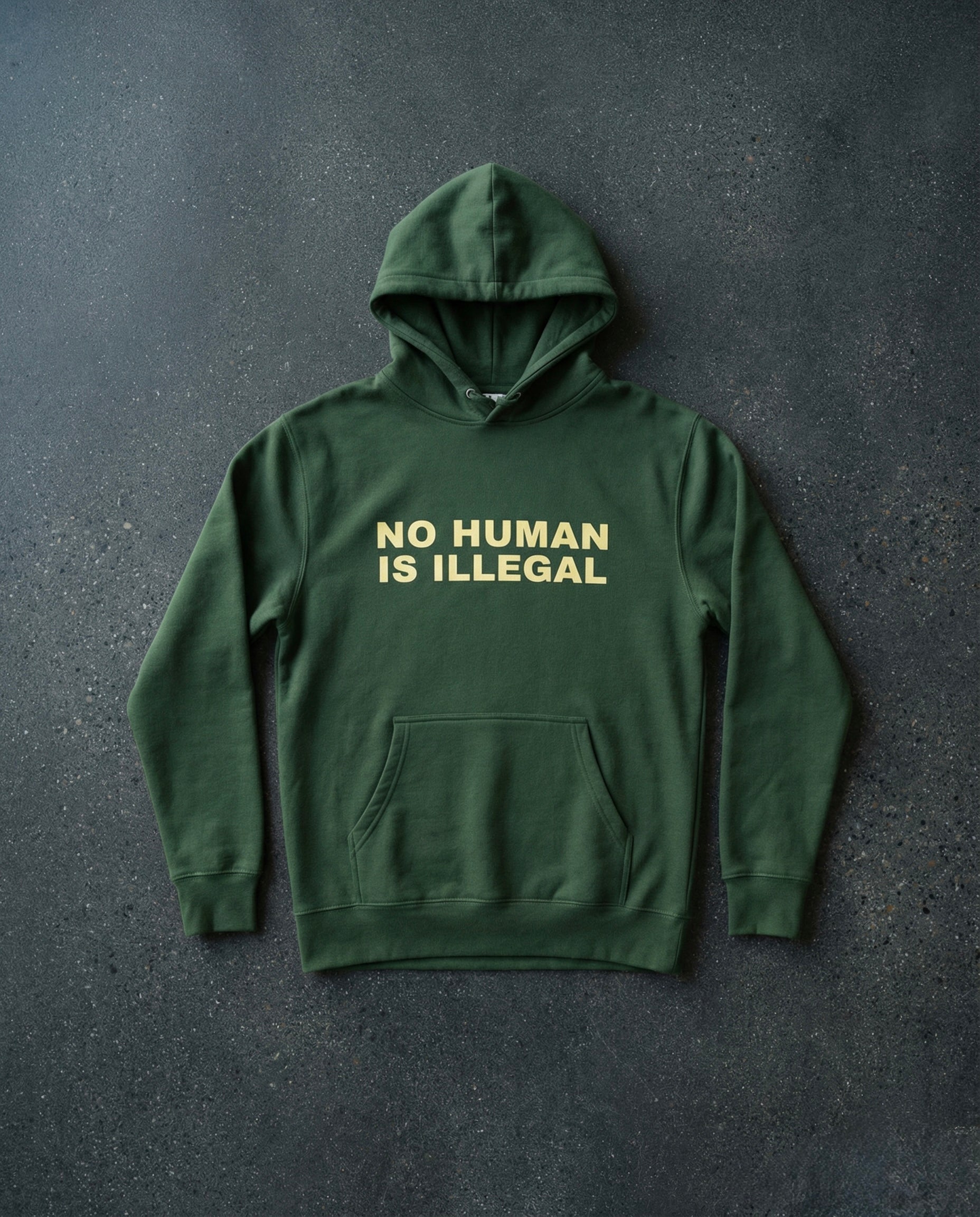 NO HUMAN IS ILLEGAL Hoodie Concrete Background in Forest | BAD BUREAU 