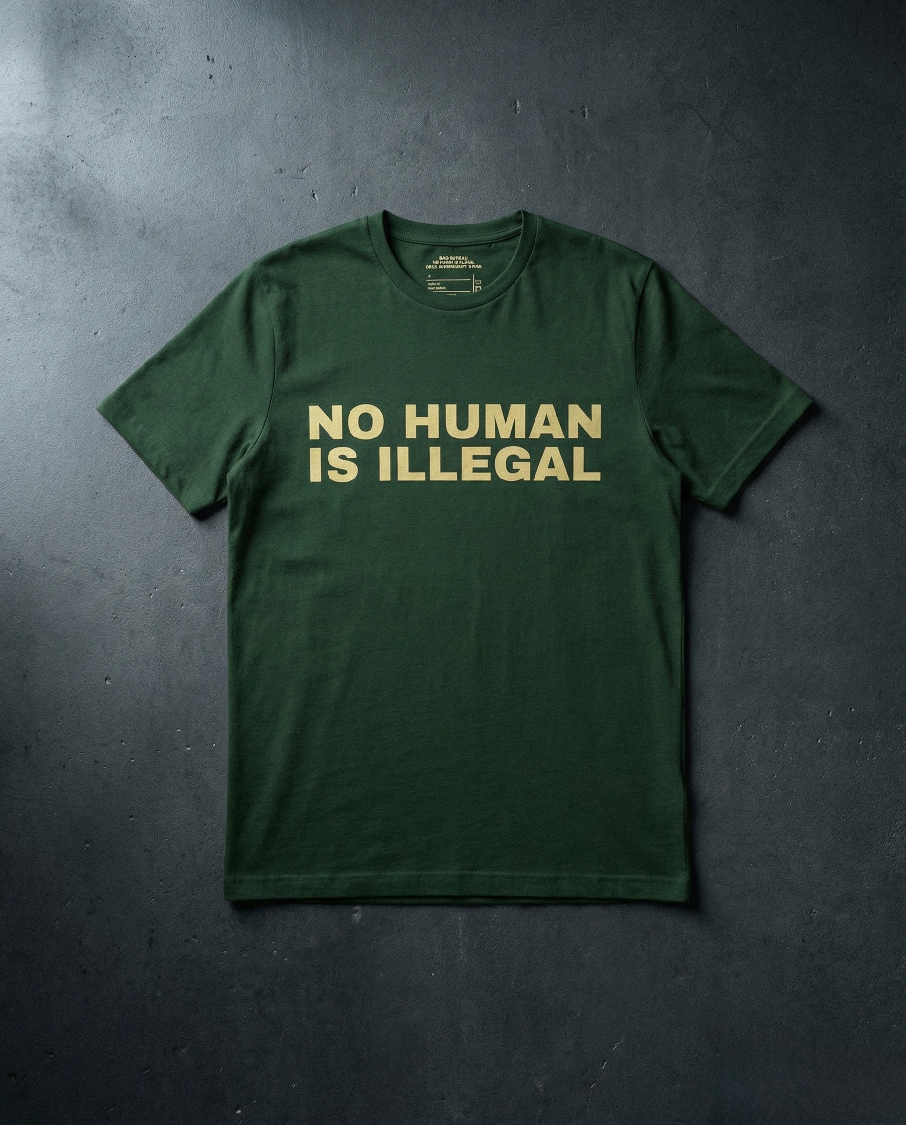NO HUMAN IS ILLEGAL T-Shirt Concrete Background in Forest | BAD BUREAU 