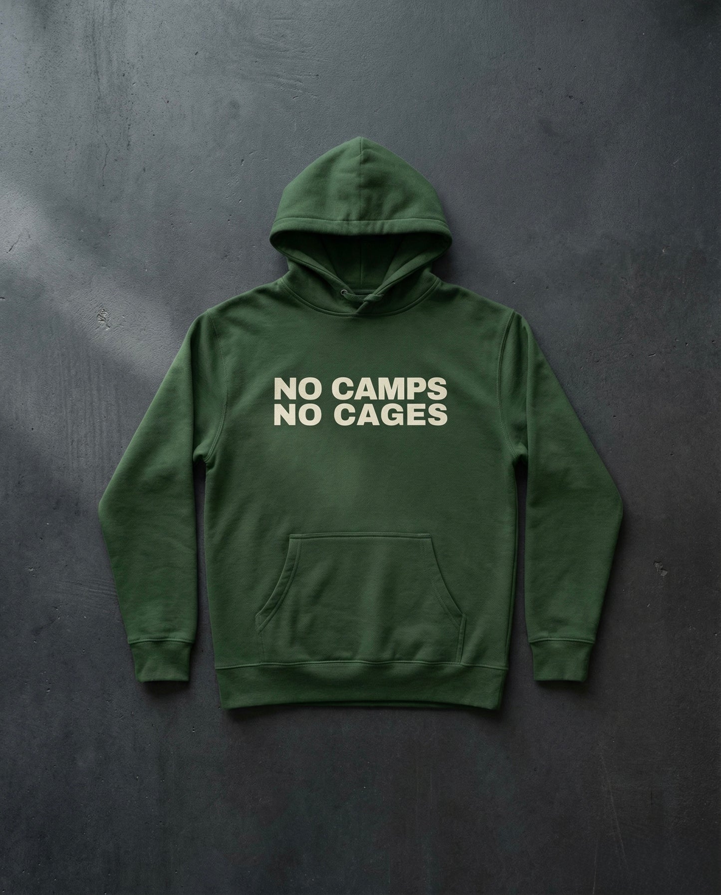 NO CAMPS NO CAGES Hoodie concrete background in forest | BAD BUREAU